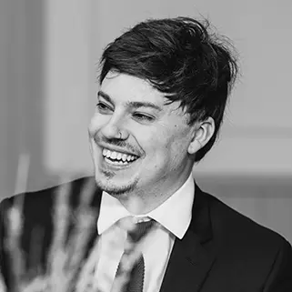 A headshot of Tom Ragan in black and white